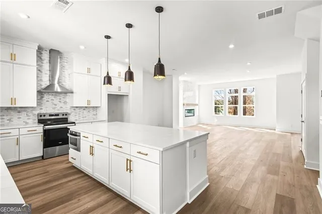 a large kitchen with stainless steel appliances lots of counter space sink and wooden floor