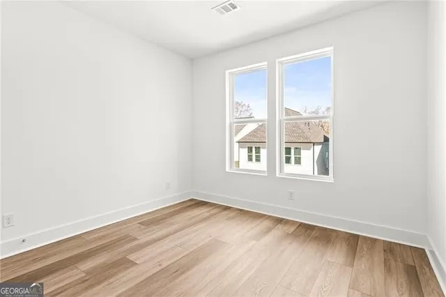 a view of an empty room with wooden floor