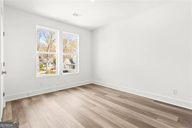 a view of a room with wooden floor and a white door