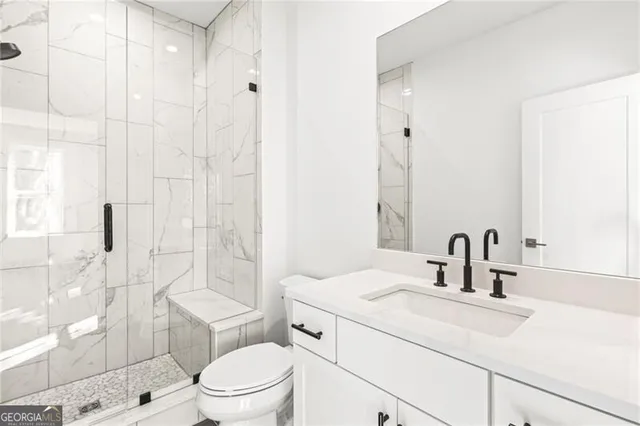 a bathroom with a sink toilet vanity and shower