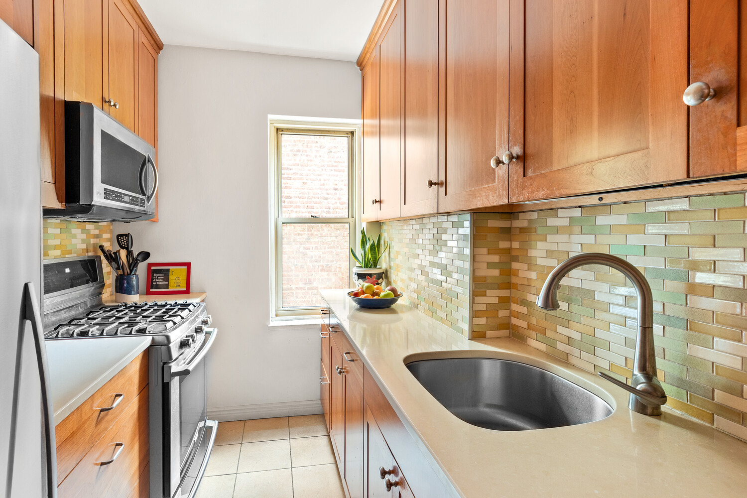 530 East 90th Street, Unit 5H Manhattan, NY 10128 - Photo 11 of 15 a kitchen with stainless steel appliances a sink a stove and cabinets