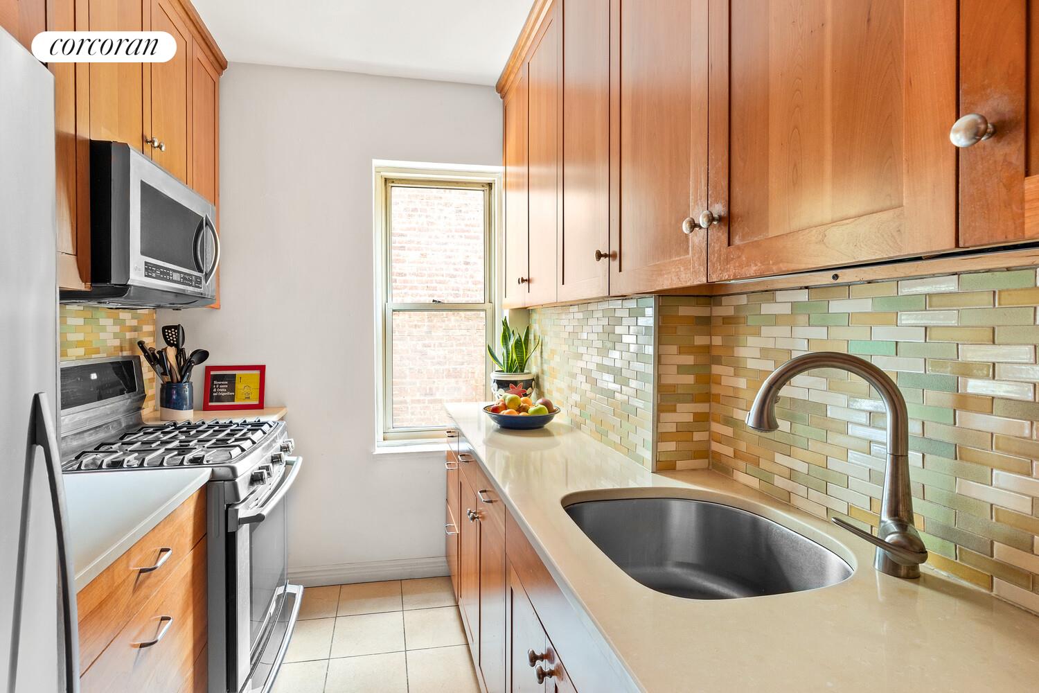 530 East 90th Street, Unit 5H Manhattan, NY 10128 - Photo 4 of 15 a kitchen with stainless steel appliances granite countertop a sink a stove and a microwave