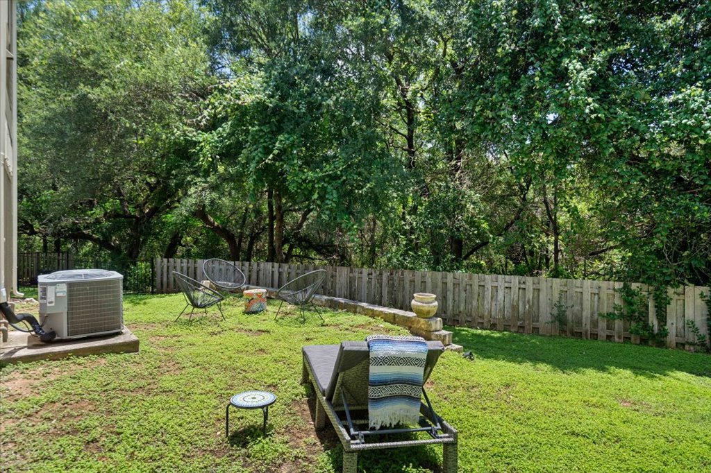 12200 Tawny Farms Road, Unit 139 Austin, TX 78748 - Photo 25 of 30 Welcome to your private outdoor oasis! The backyard is fully enclosed by a classic wooden privacy fence and opens up to a stunning canopy of mature, lush green trees. It feels incredibly peaceful and secluded out here.