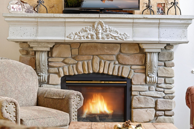 3634 North Huntsman Path, Unit C203 Eden, UT 84310 - Photo 20 of 27 Stone fireplace with an arched firebox and a decorative cast stone mantelpiece featuring corbels and carved detailing