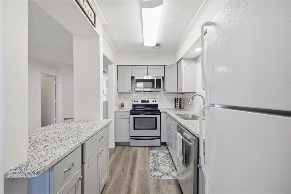 907 Roaring Springs Road Fort Worth, TX 76114 - Photo 11 of 27 a kitchen with stainless steel appliances granite countertop a stove and a sink