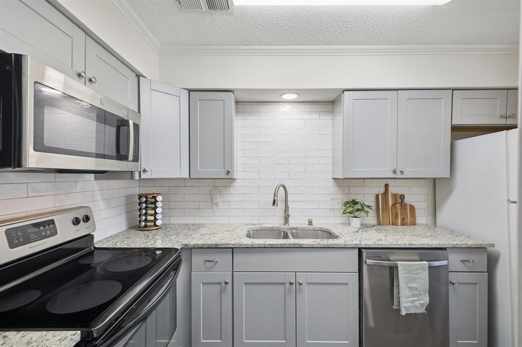 907 Roaring Springs Road Fort Worth, TX 76114 - Photo 12 of 27 a kitchen with stainless steel appliances granite countertop a sink stove and cabinets
