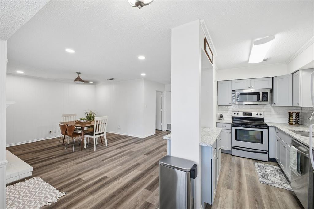 907 Roaring Springs Road Fort Worth, TX 76114 - Photo 13 of 27 a kitchen with stainless steel appliances granite countertop a stove top oven a sink island and a refrigerator