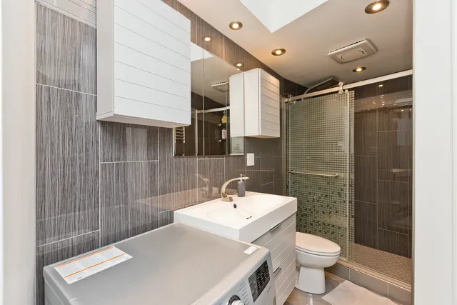 a bathroom with a sink a toilet and shower