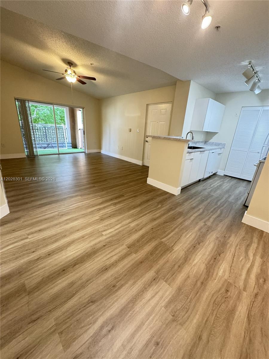 2021 Renaissance Boulevard, Unit 201 Miramar, FL 33025 - Photo 2 of 26 an empty room with wooden floor and windows