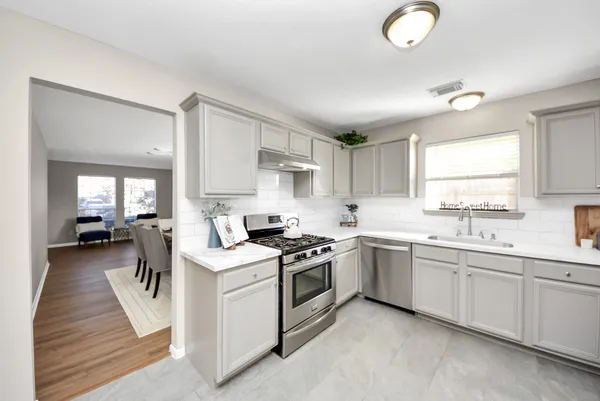a kitchen that has a sink and a stove in it