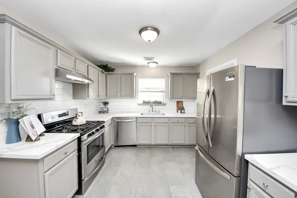 a kitchen with stainless steel appliances granite countertop a sink stove and refrigerator