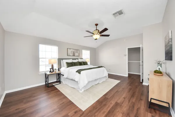 a spacious bedroom with a bed and a chandelier