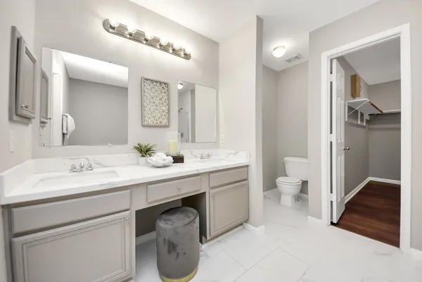 a spacious bathroom with a granite countertop sink a toilet and a mirror