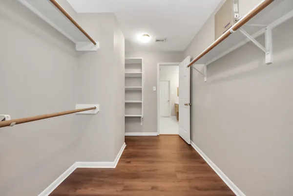 a view of walk in closet with wooden floor