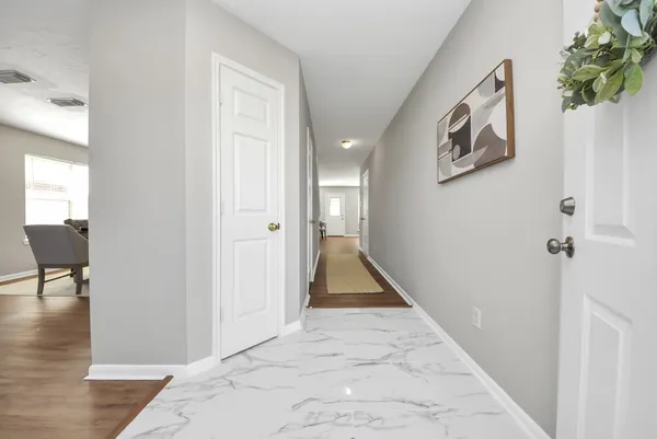 a view of a hallway with wooden floor and a living room
