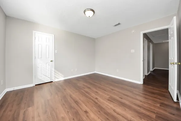 a view of an empty room with wooden floor