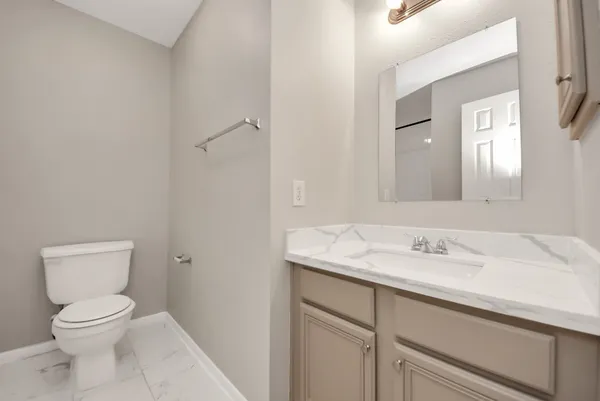 a bathroom with a sink a toilet and a mirror