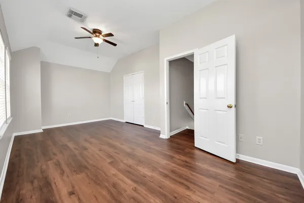 an empty room with wooden floor and closet