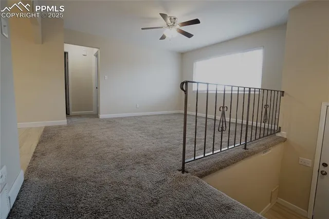a view of a hallway with a ceiling fan