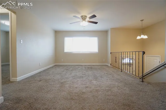 an empty room with fan and windows