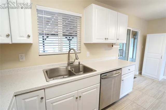 a kitchen with granite countertop white cabinets and white appliances
