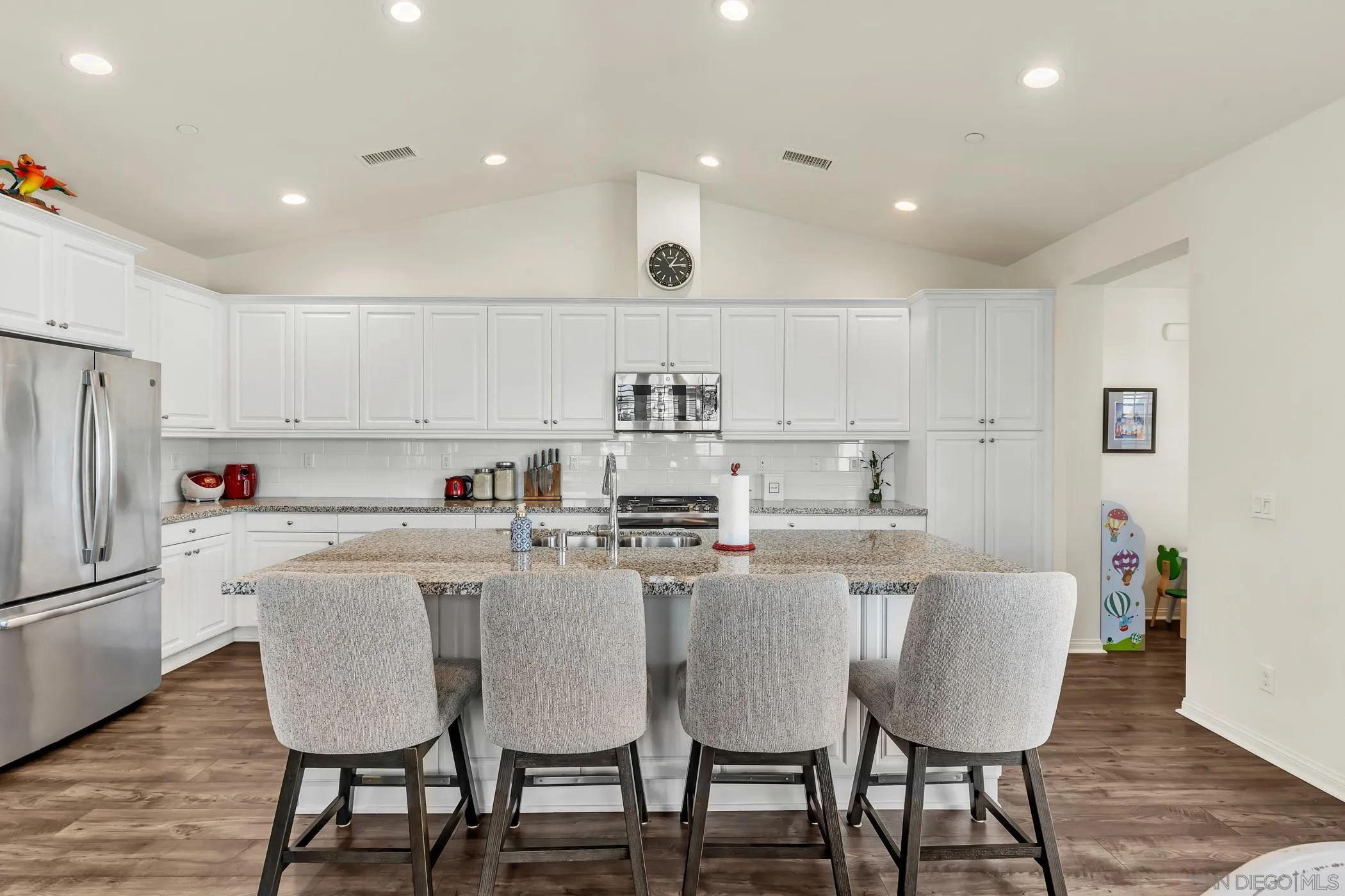 4307 Star Path Way, Unit 1 Oceanside, CA 92056 - Photo 6 of 34 a kitchen with kitchen island wooden cabinets and white stainless steel appliances