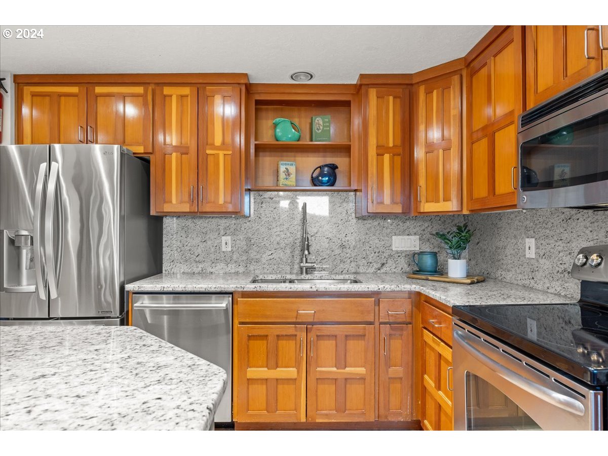 18650 South Lyons Road Oregon City, OR 97045 - Photo 19 of 47 a kitchen with stainless steel appliances granite countertop a stove a sink and a microwave