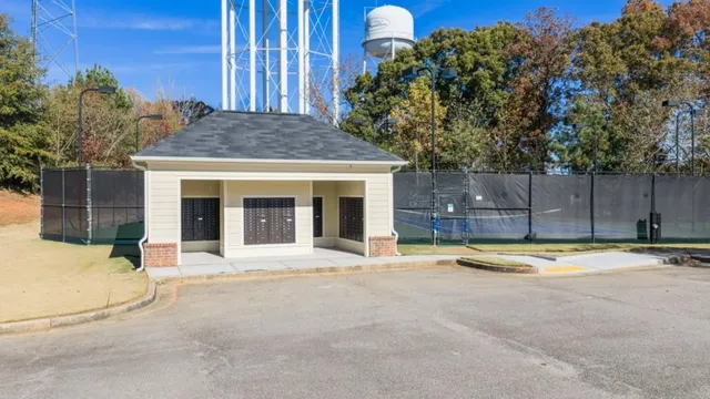a view of a tennis ground with large trees