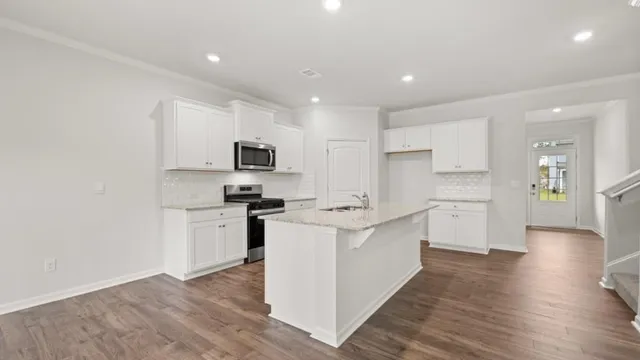 a kitchen with a sink a counter top space stainless steel appliances and cabinets