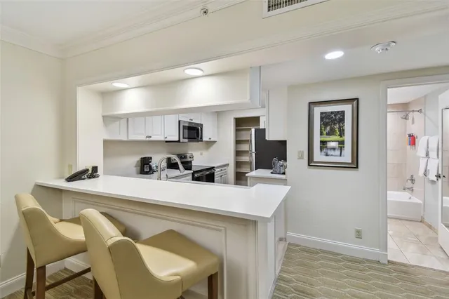 a kitchen with stainless steel appliances granite countertop a sink and a stove top oven with white cabinets