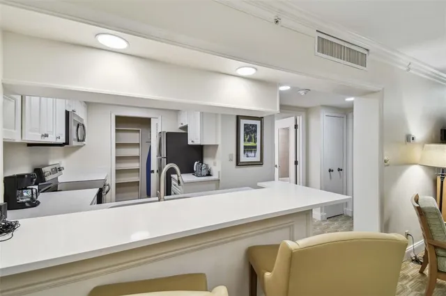 a kitchen with sink a microwave and cabinets
