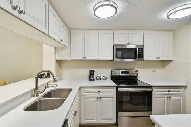 a kitchen with a sink stove and cabinets