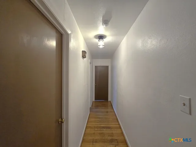 a view of a hallway with wooden floor