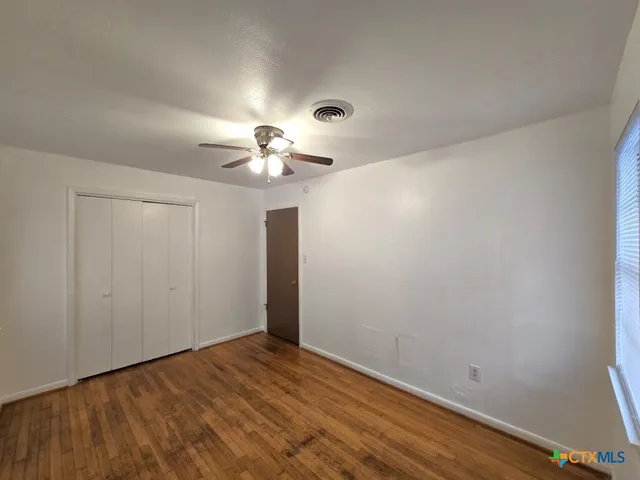 a view of an empty room with wooden floor