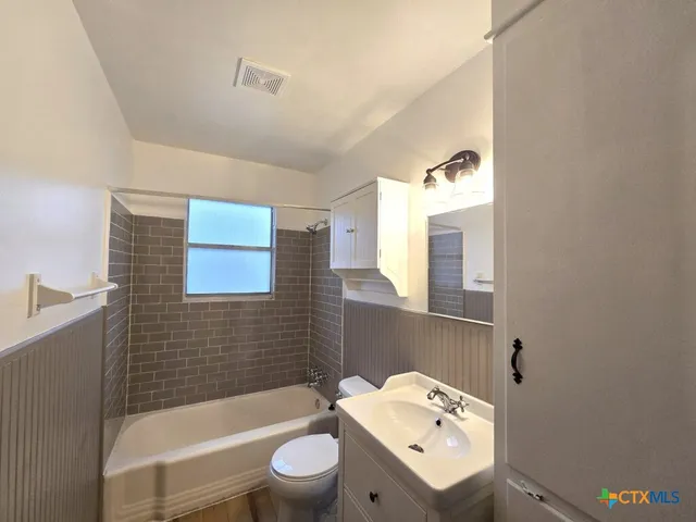 a bathroom with a sink a toilet and bathtub