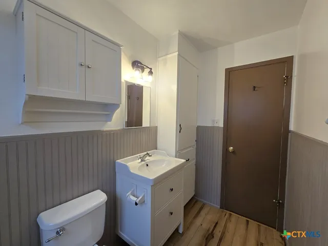 a bathroom with a sink a toilet and mirror