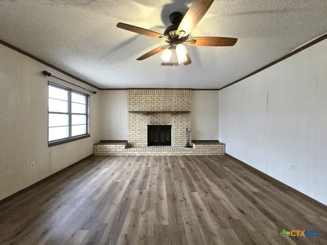 wooden floor fireplace and window in an empty room