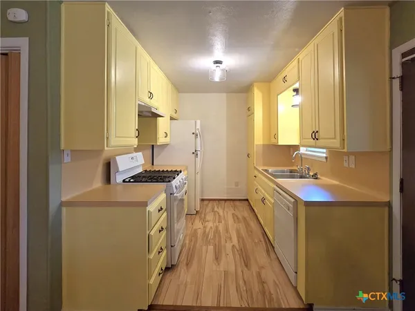 a kitchen with a sink stove and refrigerator