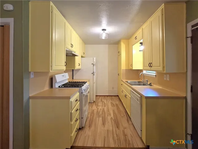 a kitchen with a sink stove and refrigerator