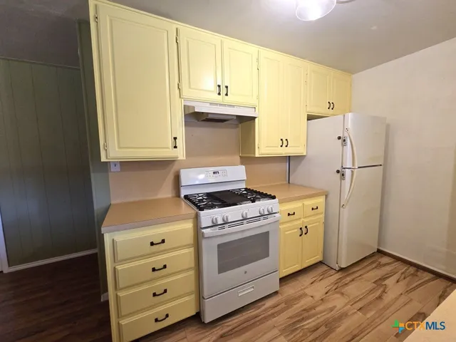 a kitchen with stainless steel appliances a stove a refrigerator and cabinets