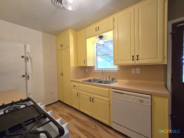 a room with a sink cabinets and wooden floor