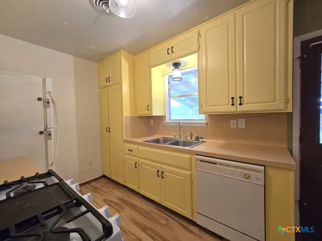 a room with a sink cabinets and wooden floor
