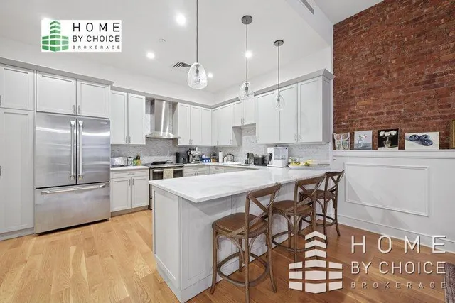 a kitchen with kitchen island a stove a sink and a refrigerator