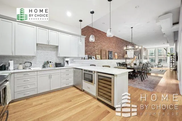 a kitchen with stainless steel appliances granite countertop a stove top oven a sink a dining table and chairs with wooden floor