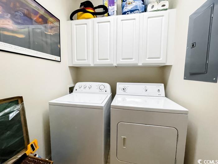 1101 Peace Pipe Place, Unit 104 Myrtle Beach, SC 29579 - Photo 17 of 22 Laundry area featuring electric panel, washer and clothes dryer, and cabinet space