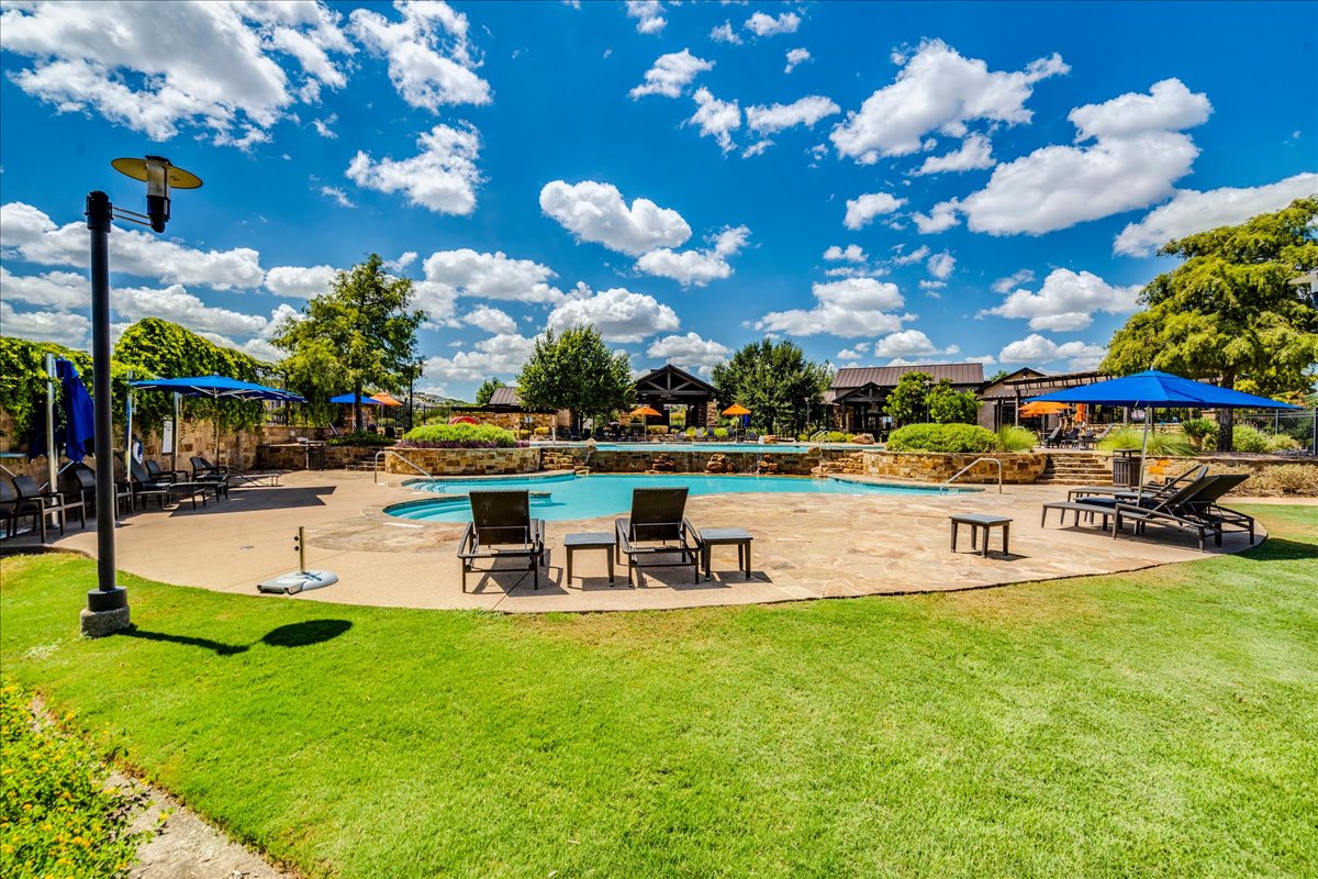 5009 Inks Clearing Lane Austin, TX 78738 - Photo 11 of 34 An inviting community swimming pool sits surrounded by stone-paved lounging areas and manicured lawns.