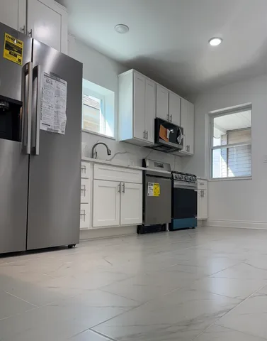 a kitchen with stainless steel appliances granite countertop a refrigerator and a stove top oven