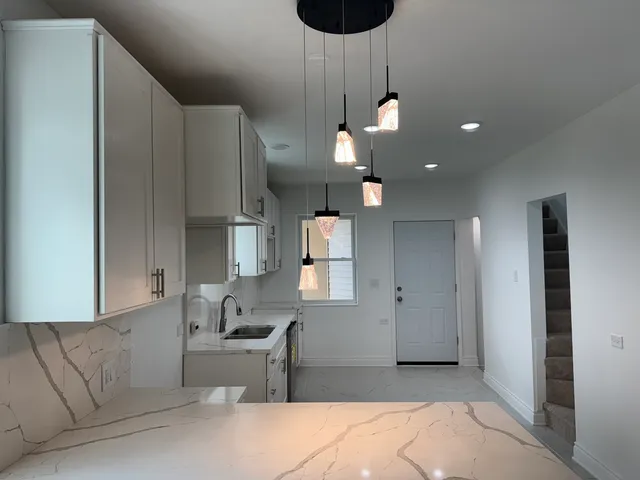 a large kitchen with a sink a refrigerator and window