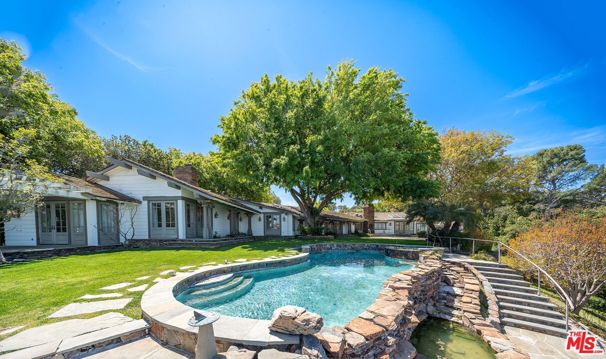 a view of a house with swimming pool and sitting area