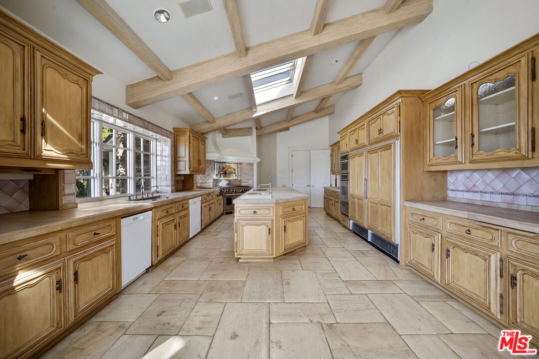 74 Saddleback Road Rolling Hills, CA 90274 - Photo 9 of 65 a large kitchen with a stove top oven cabinets a sink and a window